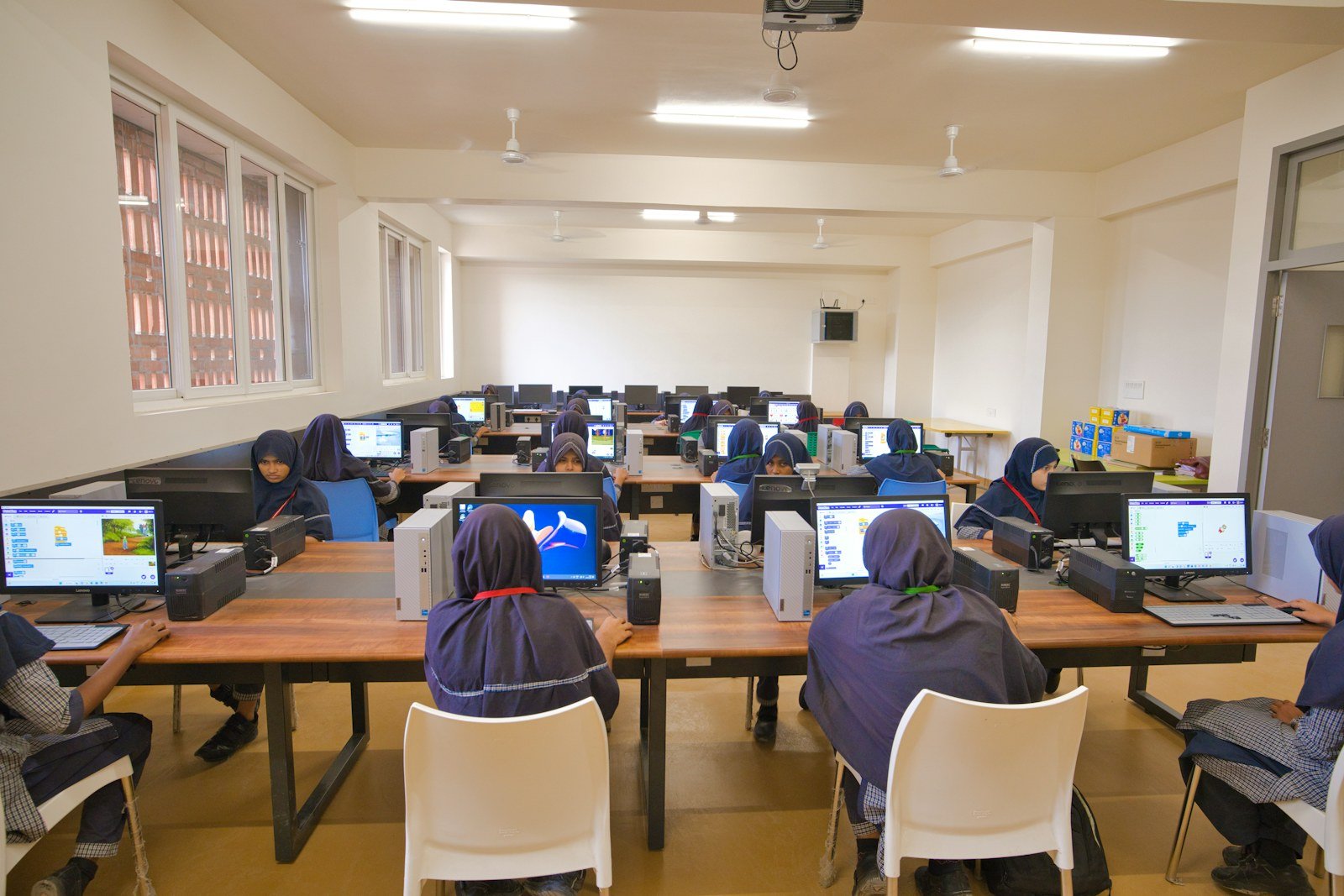Students in hijabs working in a school computer lab