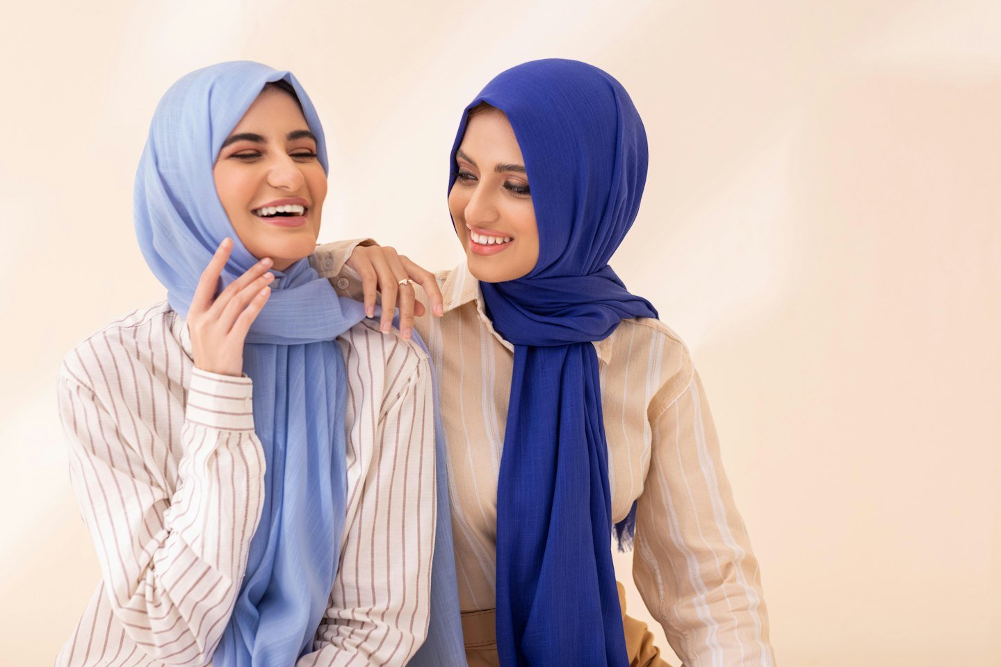 Two women in hijabs sharing a happy moment