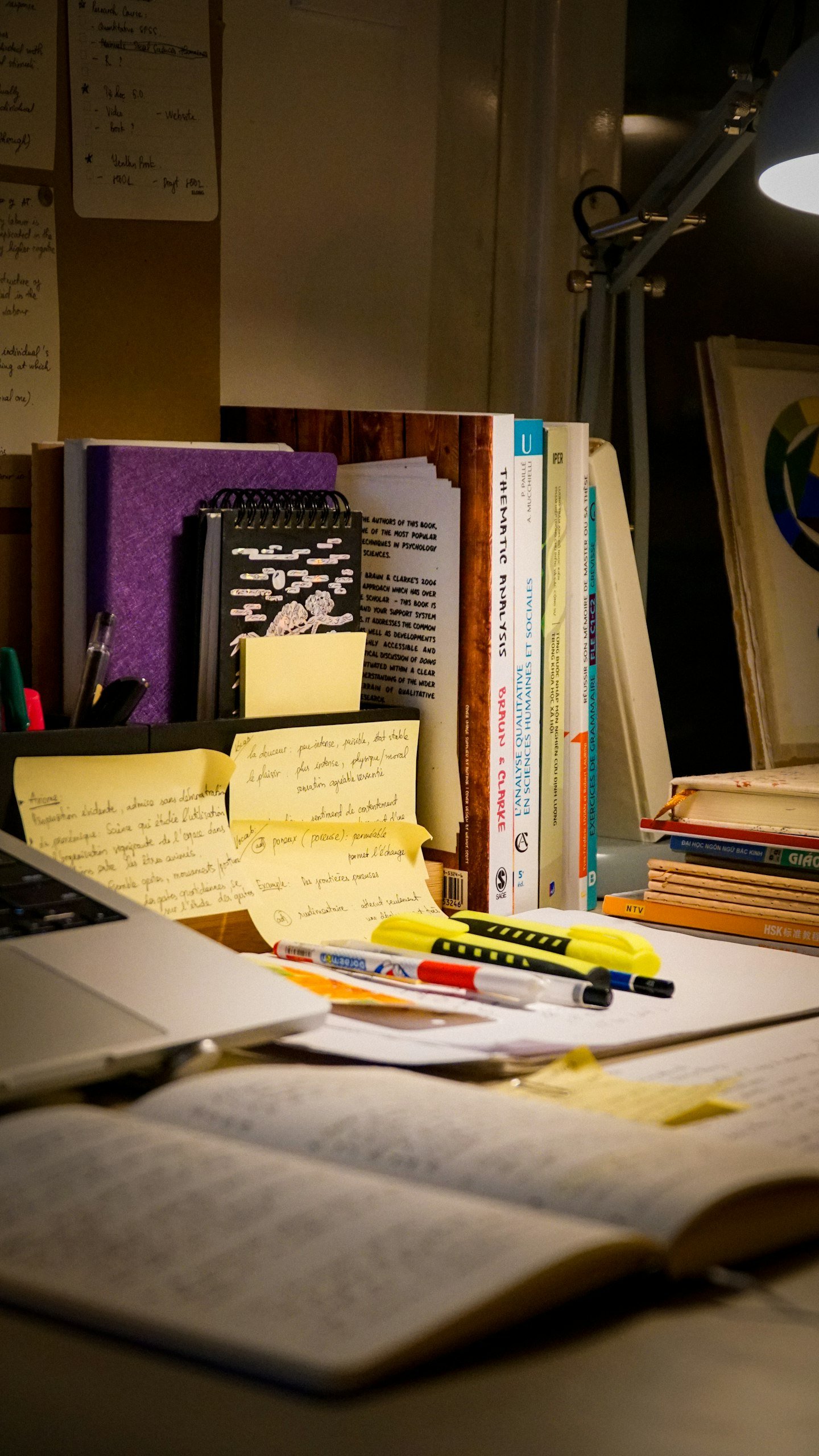 An open book, laptop and notes on a study desk