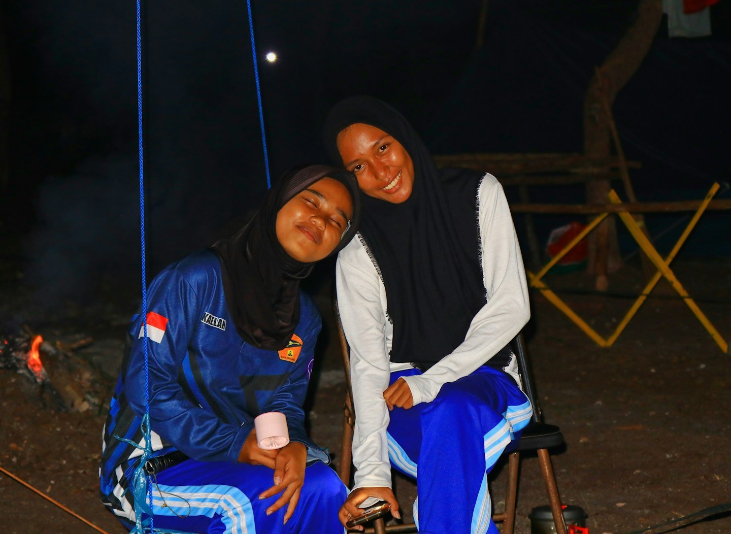 Two women in hijabs sitting together outdoors